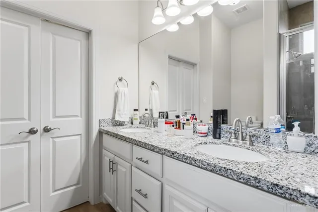 a bathroom with double sink and a mirror