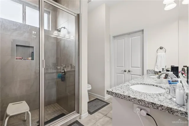 a bathroom with a granite countertop sink a toilet and shower