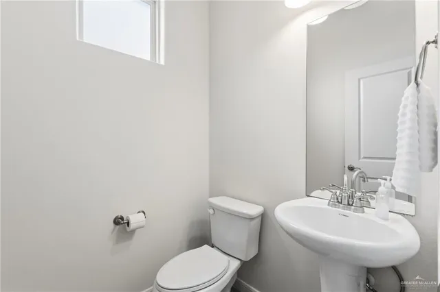 a bathroom with a sink a toilet and mirror