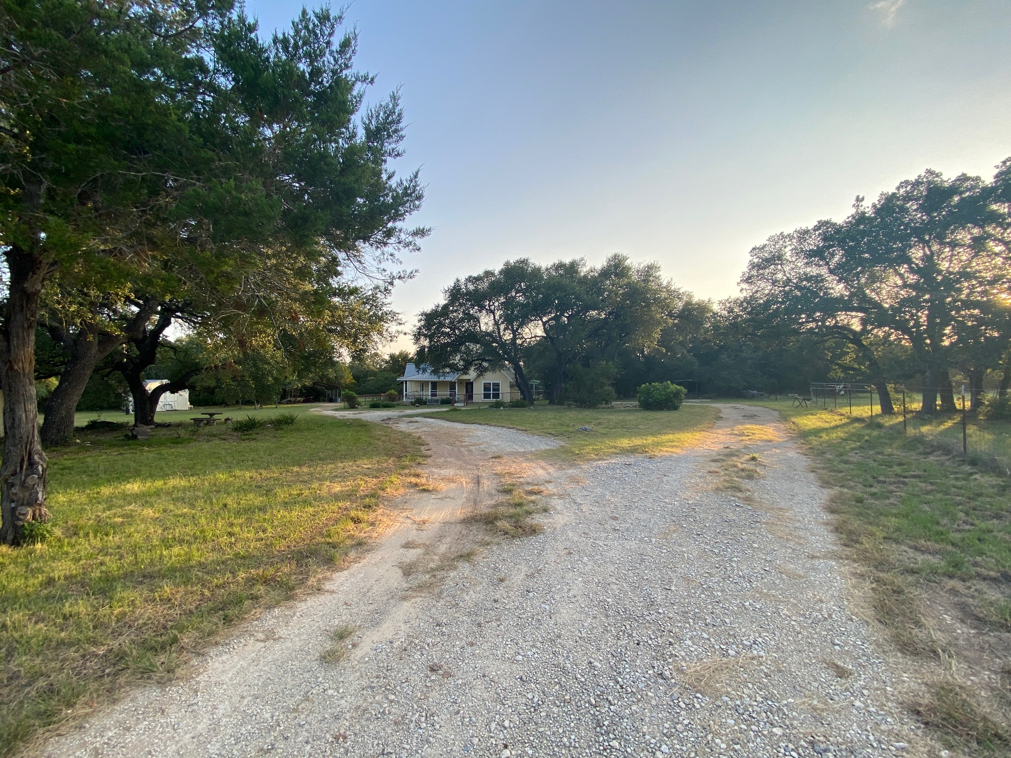 306 Plainview Road Wimberley, TX 78676 - Photo 28 of 29 A long, winding gravel driveway leads to a charming residence surrounded by mature trees.