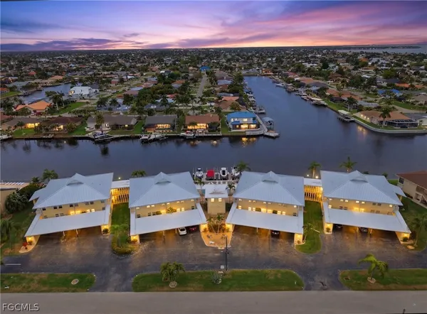 an aerial view of a city with lots of residential buildings ocean and mountain view in back