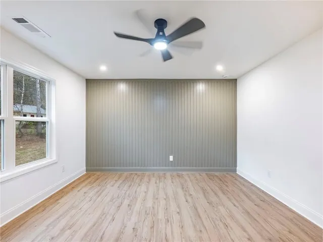 a view of a room with wooden floor and a ceiling fan