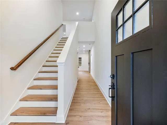 a view of staircase with lots of frames on wall and a window