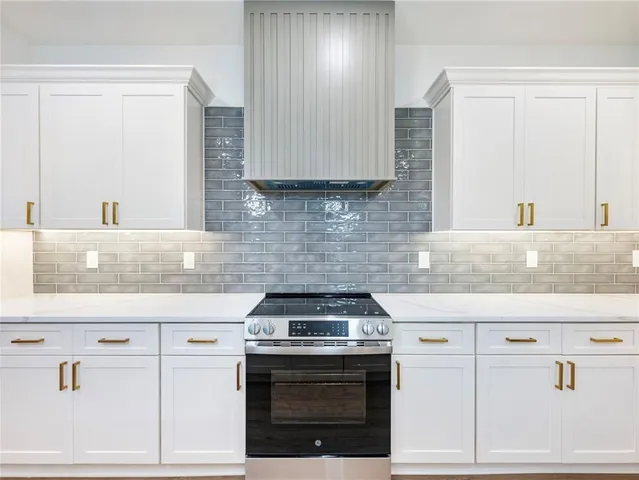 a kitchen with granite countertop white cabinets and white appliances