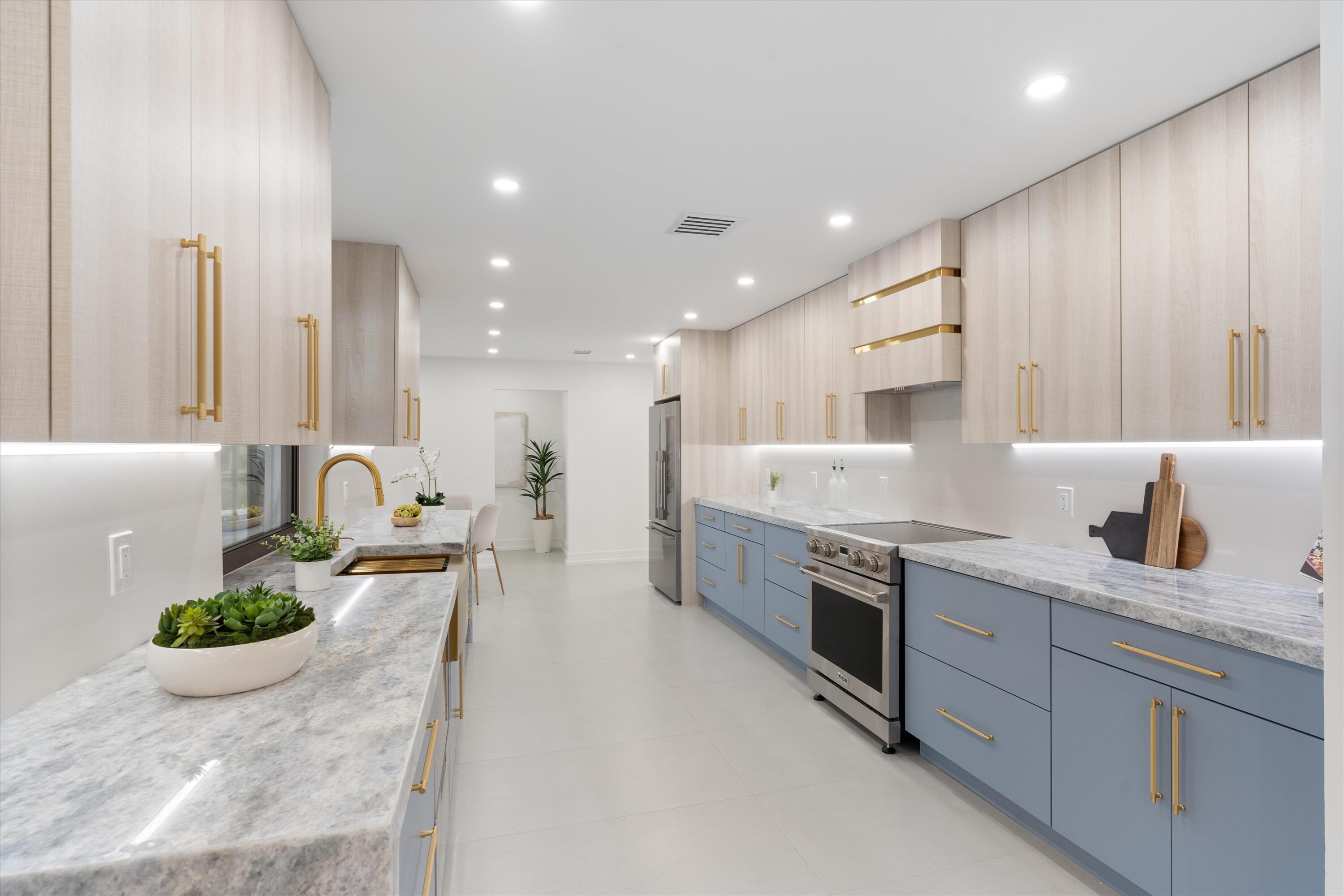 21766 Beachnut Drive Boca Raton, FL 33433 - Photo 16 of 64 a large kitchen with stainless steel appliances lots of white cabinets a stove and a sink