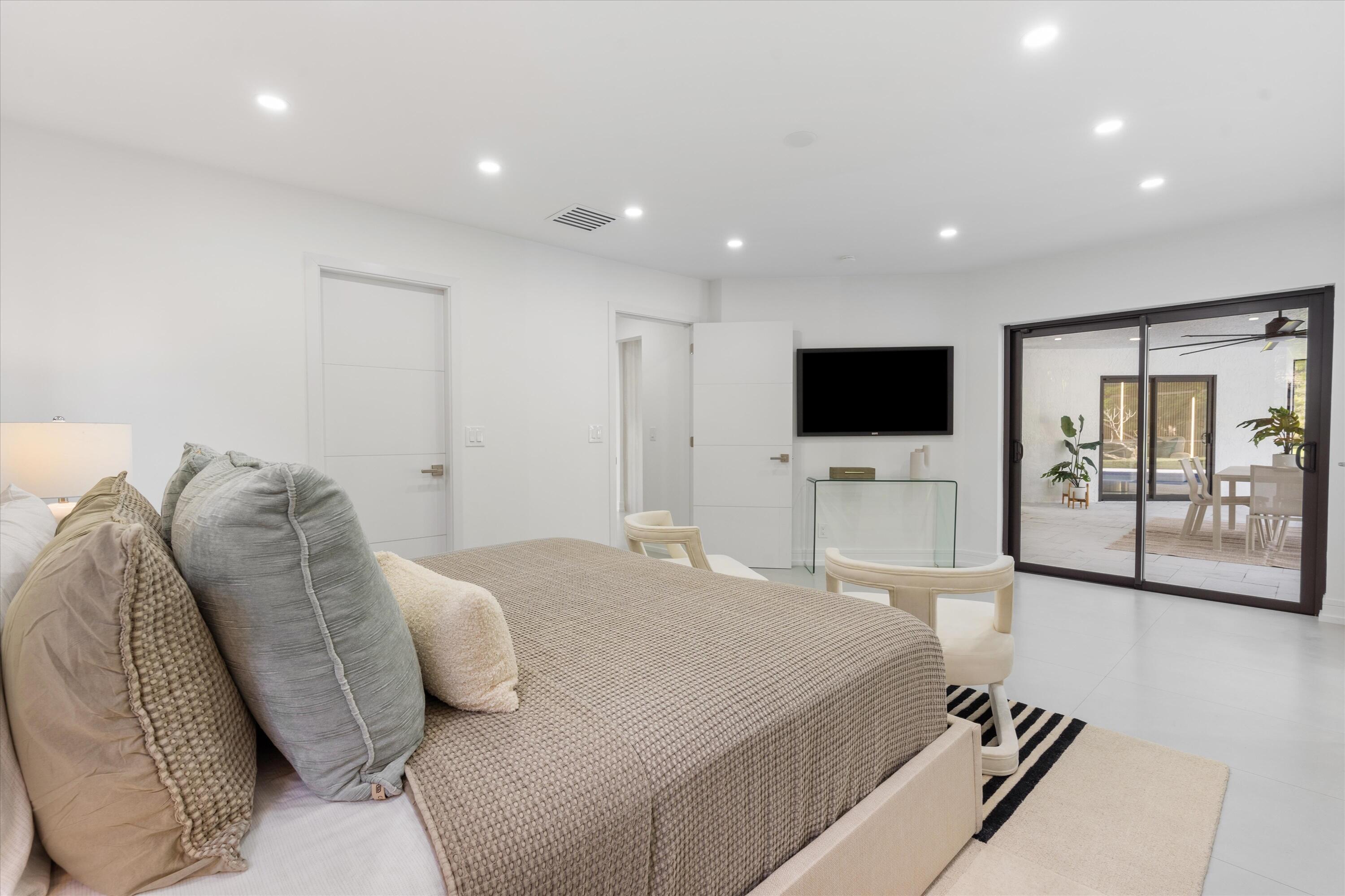 21766 Beachnut Drive Boca Raton, FL 33433 - Photo 29 of 64 a spacious bedroom with a bed and a flat screen tv