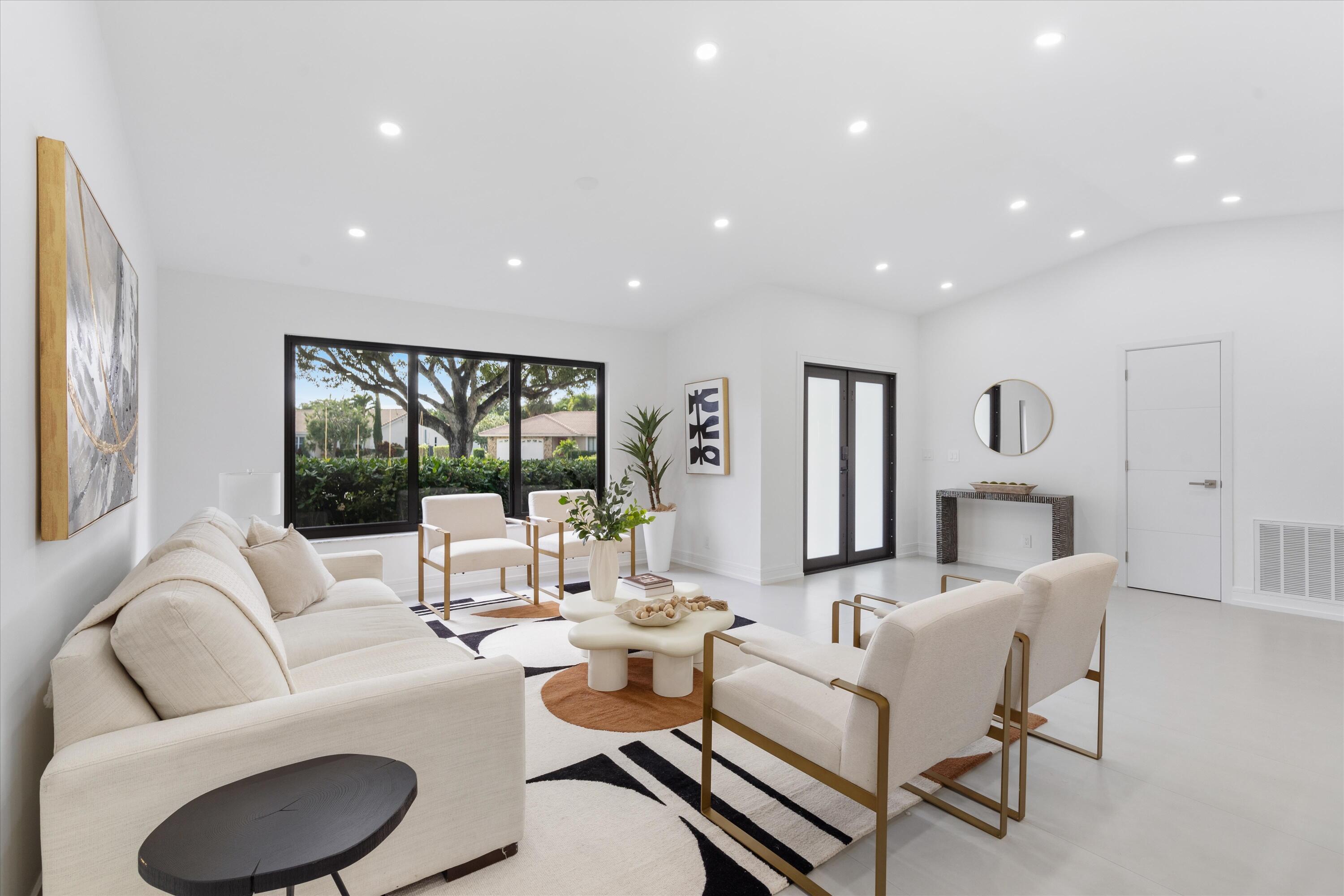 21766 Beachnut Drive Boca Raton, FL 33433 - Photo 6 of 64 a living room with furniture a large window and a fireplace