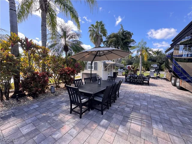 a view of a patio with table and chairs under an umbrella