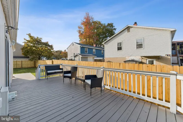 a view of a house with wooden deck and furniture