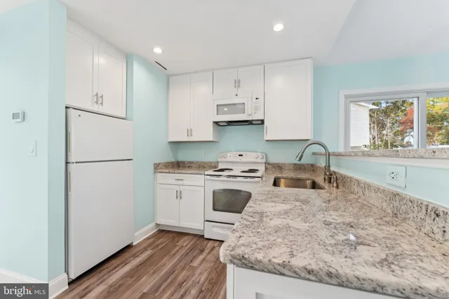 a kitchen with a refrigerator a stove a sink and a window