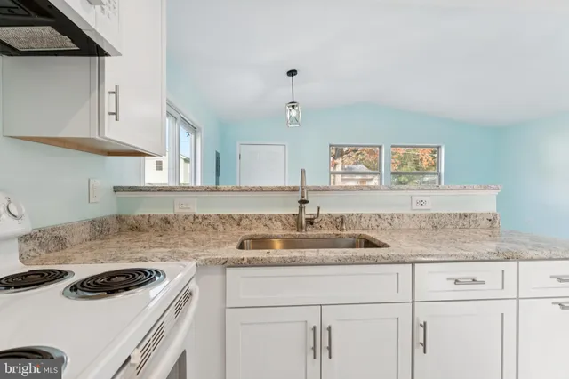 a kitchen with a sink stove and cabinets