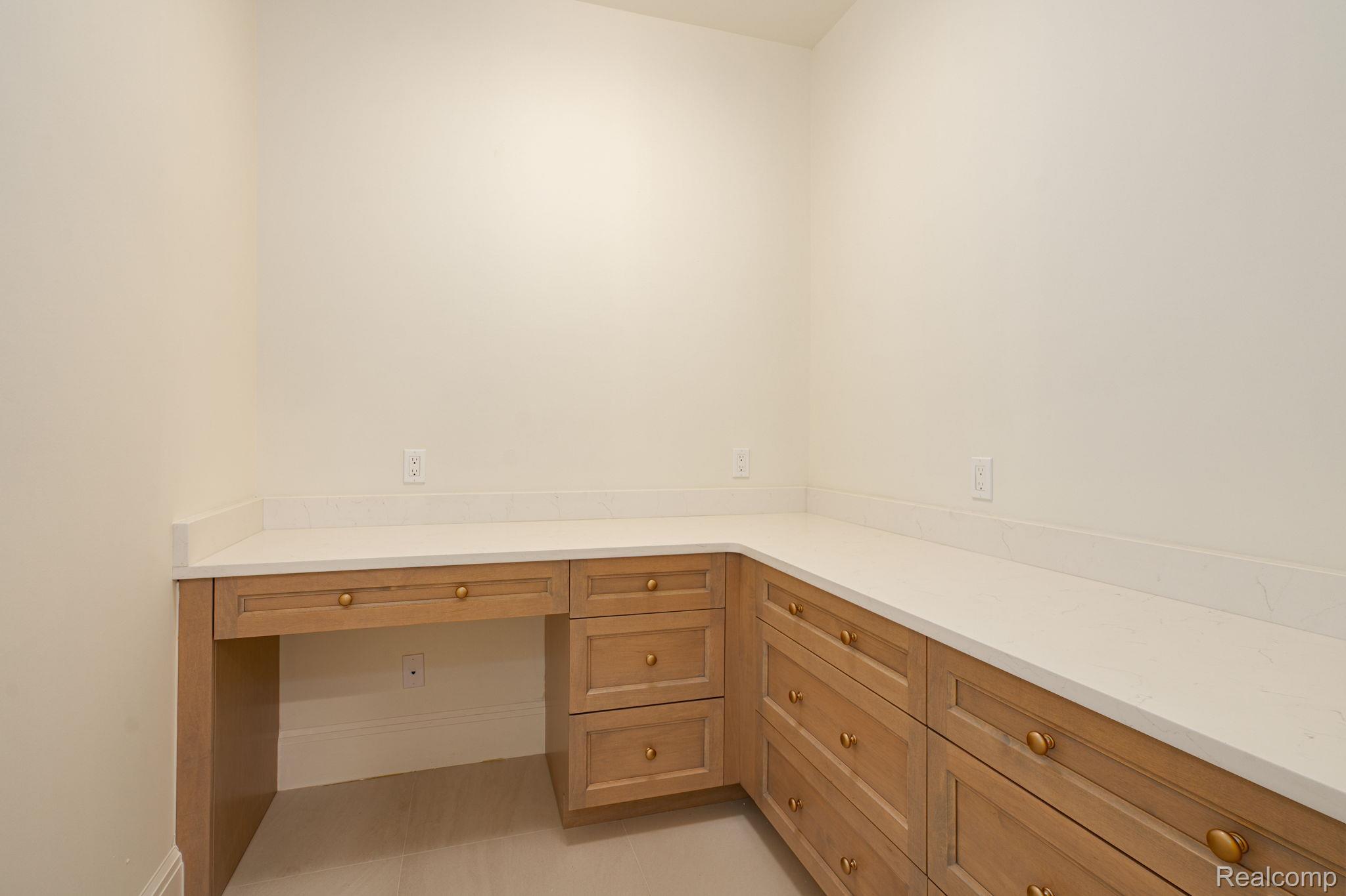 3836 Coachwood Lane Rochester, MI 48309 - Photo 45 of 82 Built-in desk and cabinetry featuring light wood-finish doors and drawers, topped with light solid-surface countertops