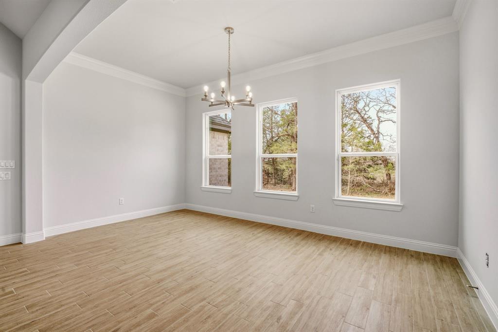 2017 Forest Bridge Azle, TX 76020 - Photo 13 of 30 an empty room with wooden floor chandelier and windows