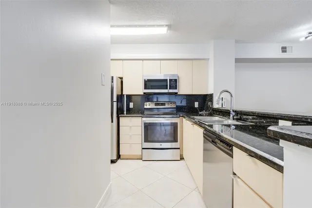 a kitchen with stainless steel appliances granite countertop a stove and a microwave