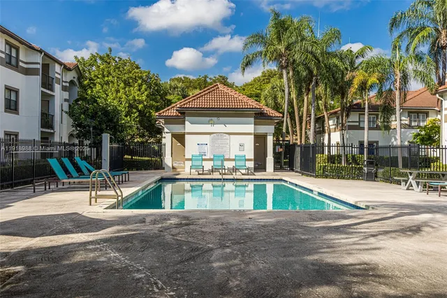 a view of a house with a swimming pool and sitting area