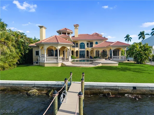 a row of palm trees in front of house