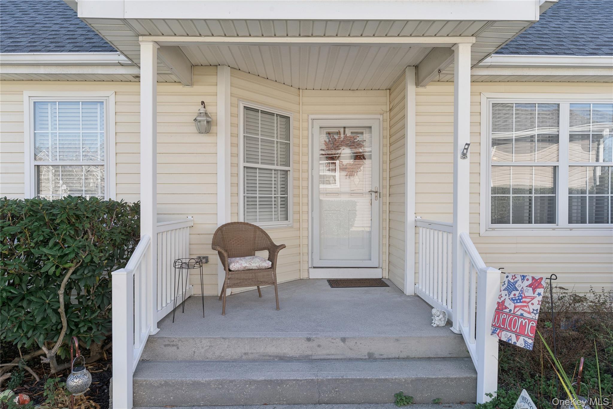 View of exterior entry featuring a porch and roof with shingles