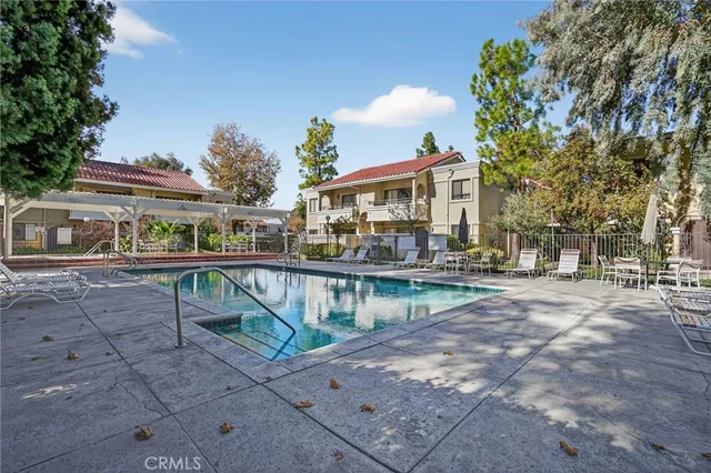 a view of house with outdoor seating area and trees