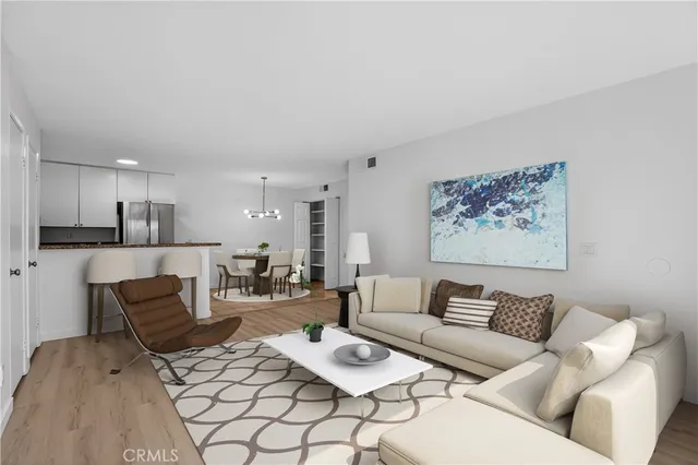 a living room with furniture and a dining table with kitchen view