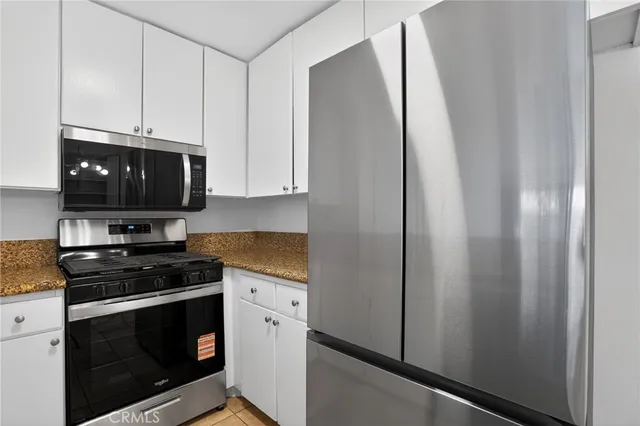 a kitchen with stainless steel appliances a stove a microwave and a sink