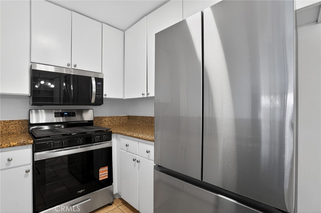 18808 Mandan Street, Unit 309 Canyon Country, CA 91351 - Photo 4 of 19 a kitchen with stainless steel appliances a stove a microwave and a sink