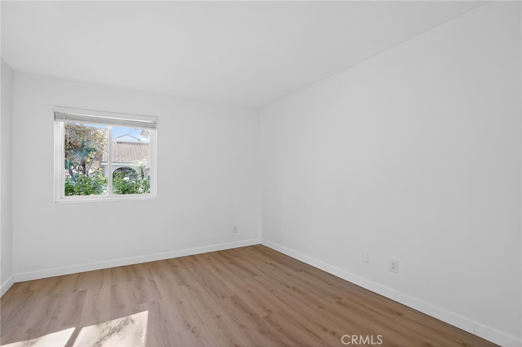 18808 Mandan Street, Unit 309 Canyon Country, CA 91351 - Photo 9 of 19 a view of an empty room with wooden floor and a window