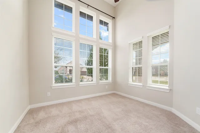 an empty room with a window and a fan