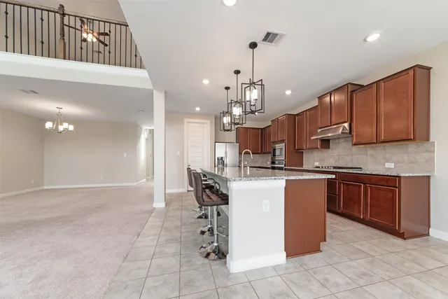 a kitchen with stainless steel appliances granite countertop wooden cabinets a sink and dishwasher a refrigerator with wooden cabinets