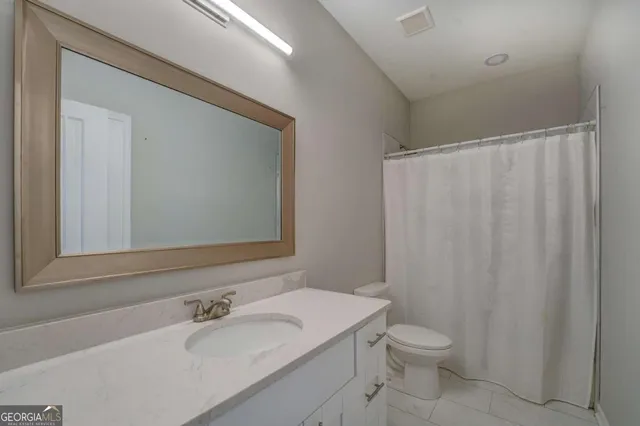 a bathroom with a sink a toilet and shower curtain