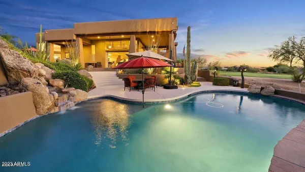 a backyard of a house with table and chairs