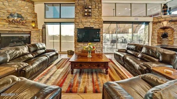 a living room with furniture a flat screen tv and a floor to ceiling window