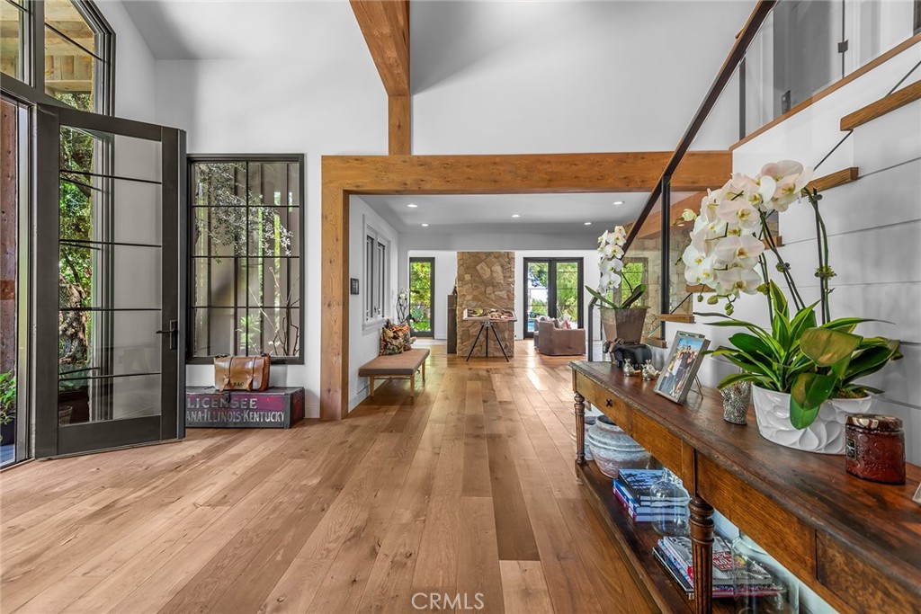 5207 Saddle Creek Road Hidden Hills, CA 91302 - Photo 3 of 54 a hallway with wooden floor table and chairs