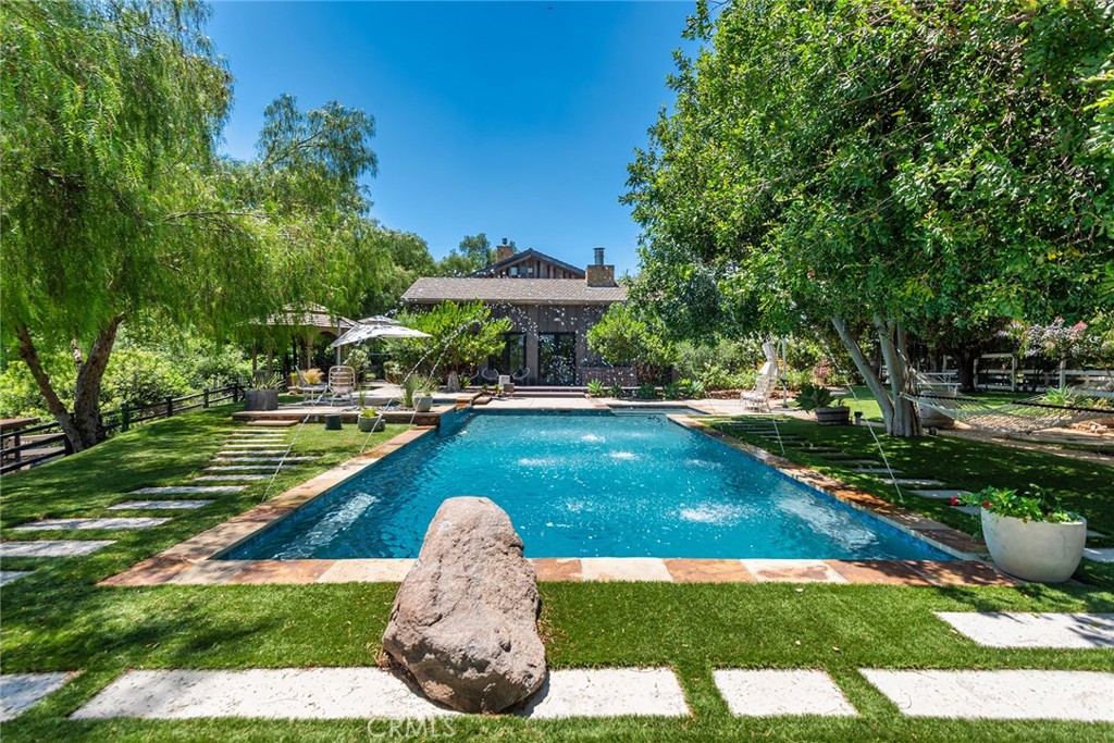 5207 Saddle Creek Road Hidden Hills, CA 91302 - Photo 37 of 54 a view of a swimming pool with a garden