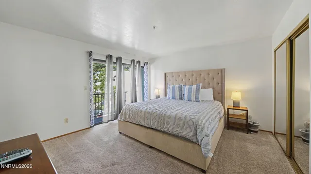 a bedroom with a large bed and a flat tv screen