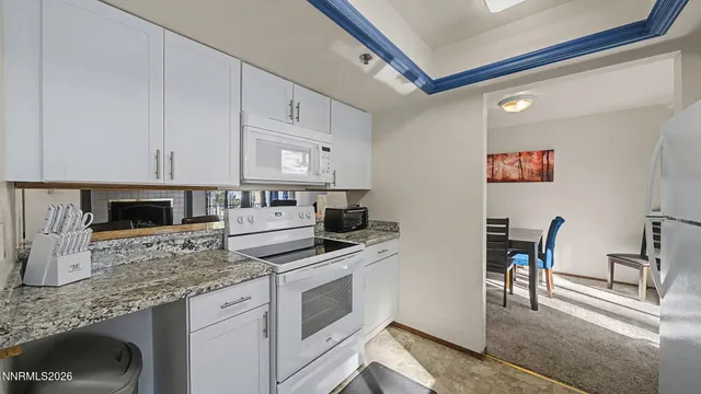 a kitchen with white cabinets and appliances