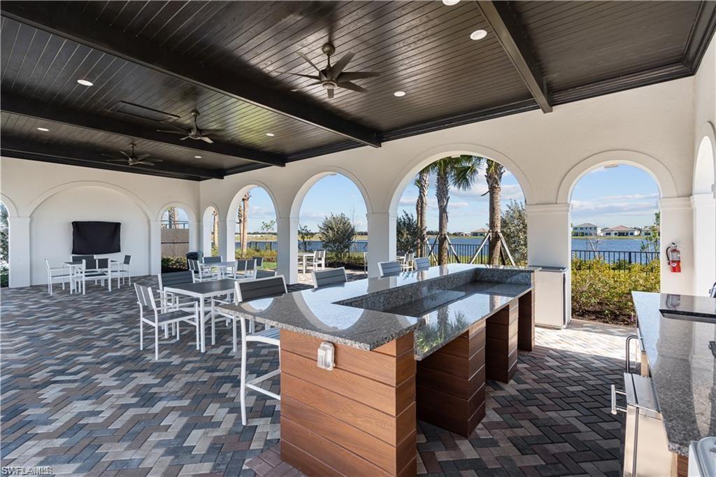 5114 Genoa Street Immokalee, FL 34142 - Photo 32 of 34 View of patio with a ceiling fan, an outdoor bar and dining area, a water view, and exterior kitchen