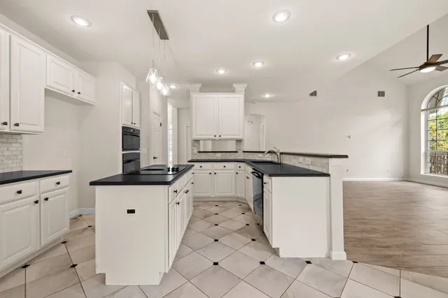 a kitchen with stainless steel appliances kitchen island granite countertop a sink and a stove