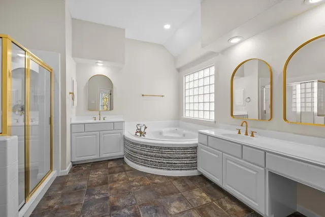 a spacious bathroom with a sink a mirror a bathtub and next to a window