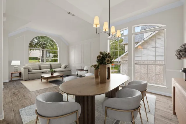 a dining room with furniture a chandelier and wooden floor