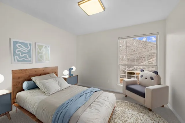 a bedroom with a bed and a couch next to a window