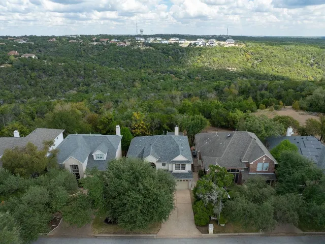an aerial view of residential houses with outdoor space and trees