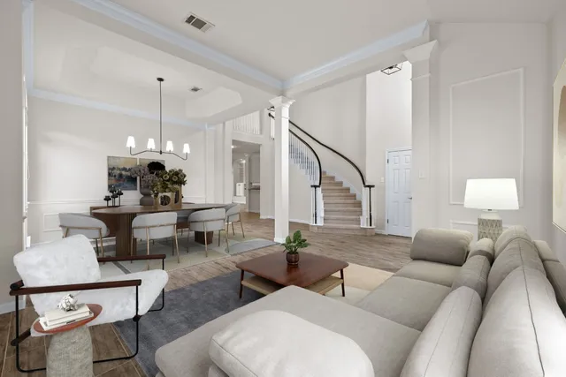 a living room with couches a fireplace and a dining table with wooden floor