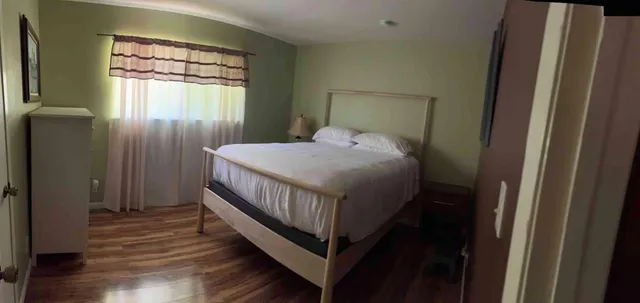 a bed sitting in a bedroom next to a window