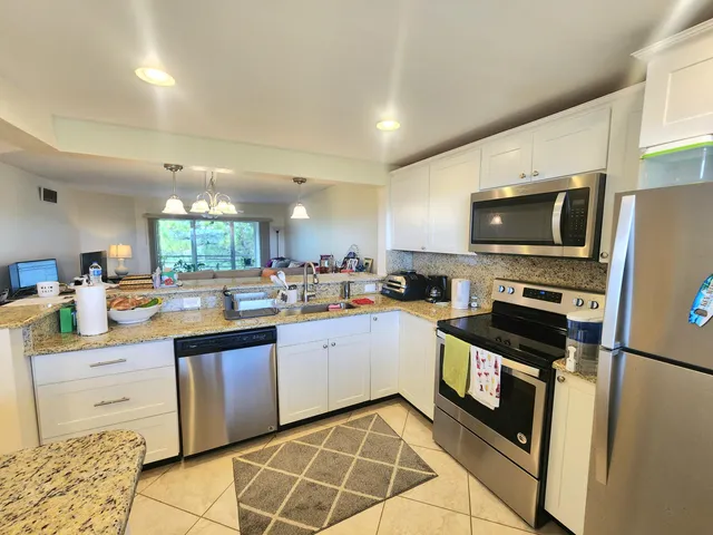 a kitchen with stainless steel appliances a stove sink microwave and cabinets