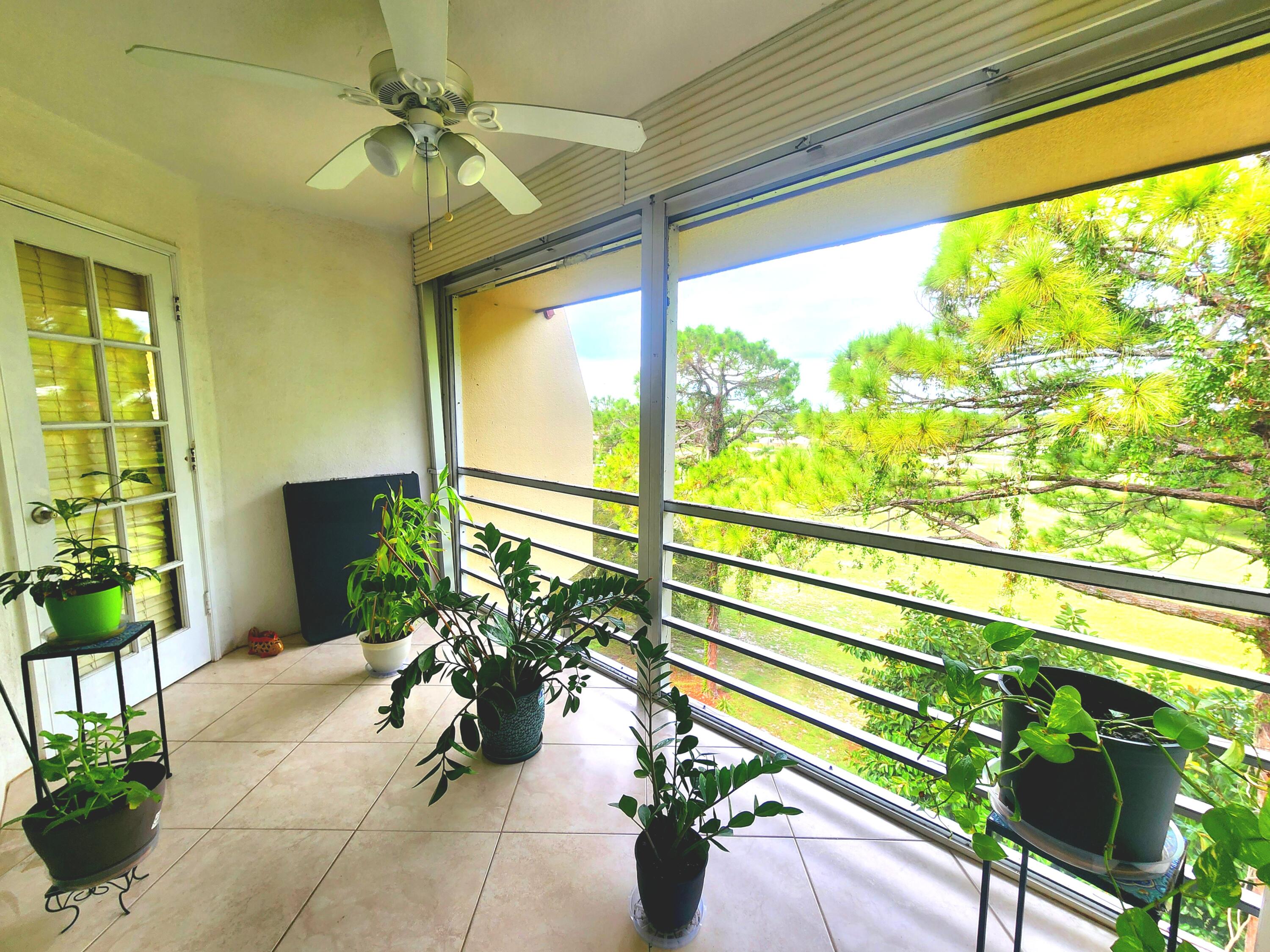 3755 Via Poinciana, Unit 607 Lake Worth, FL 33467 - Photo 7 of 19 a view of a porch with chairs and potted plants