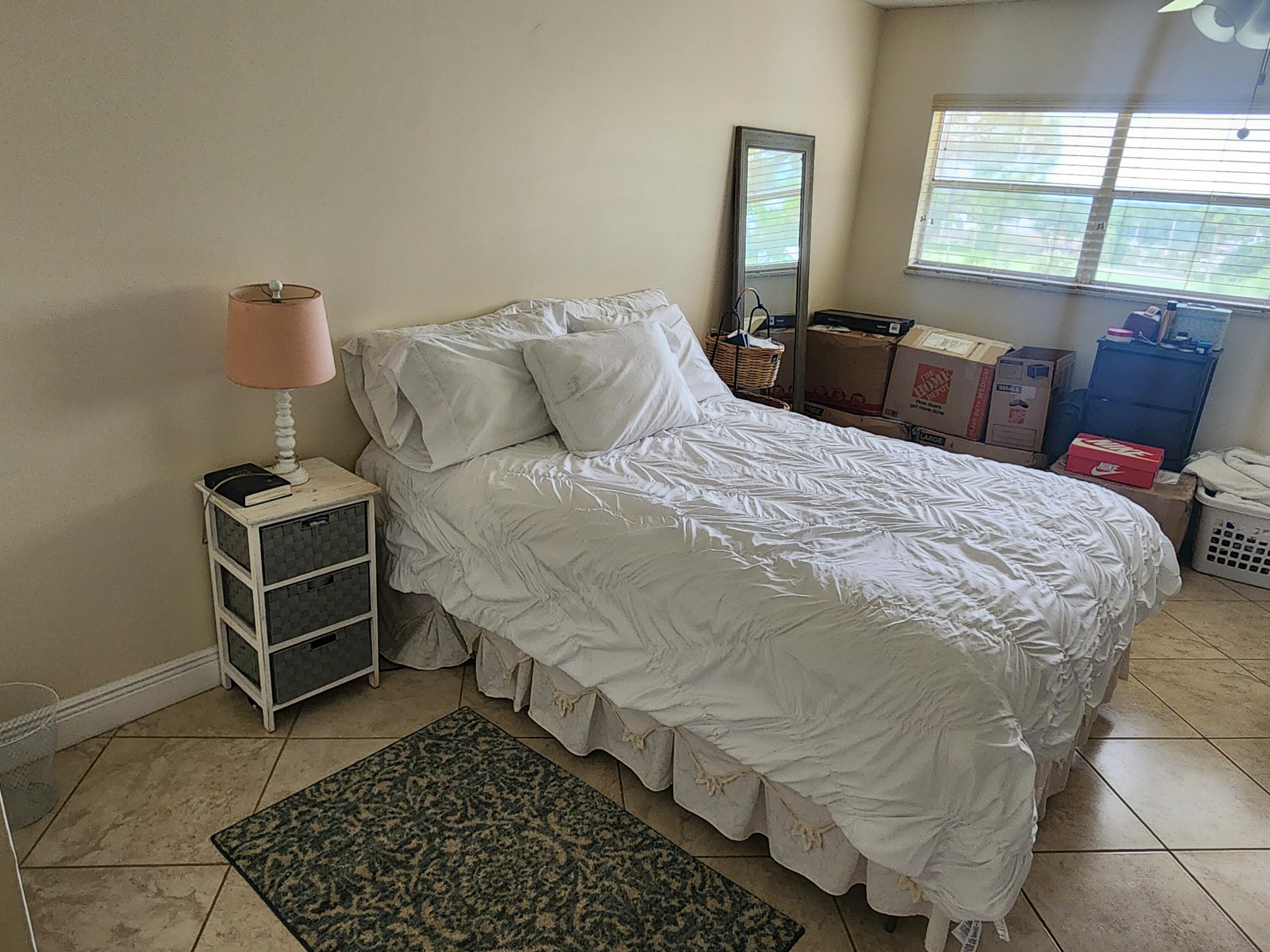 3755 Via Poinciana, Unit 607 Lake Worth, FL 33467 - Photo 9 of 19 a bed sitting in a bedroom next to a window