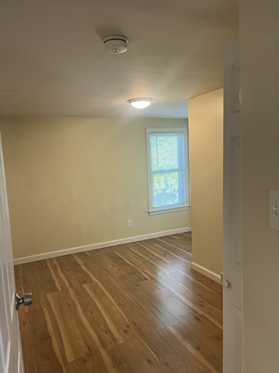 41 Winter Street, Unit 2R Fitchburg, MA 01420 - Photo 13 of 13 an empty room with wooden floor and windows