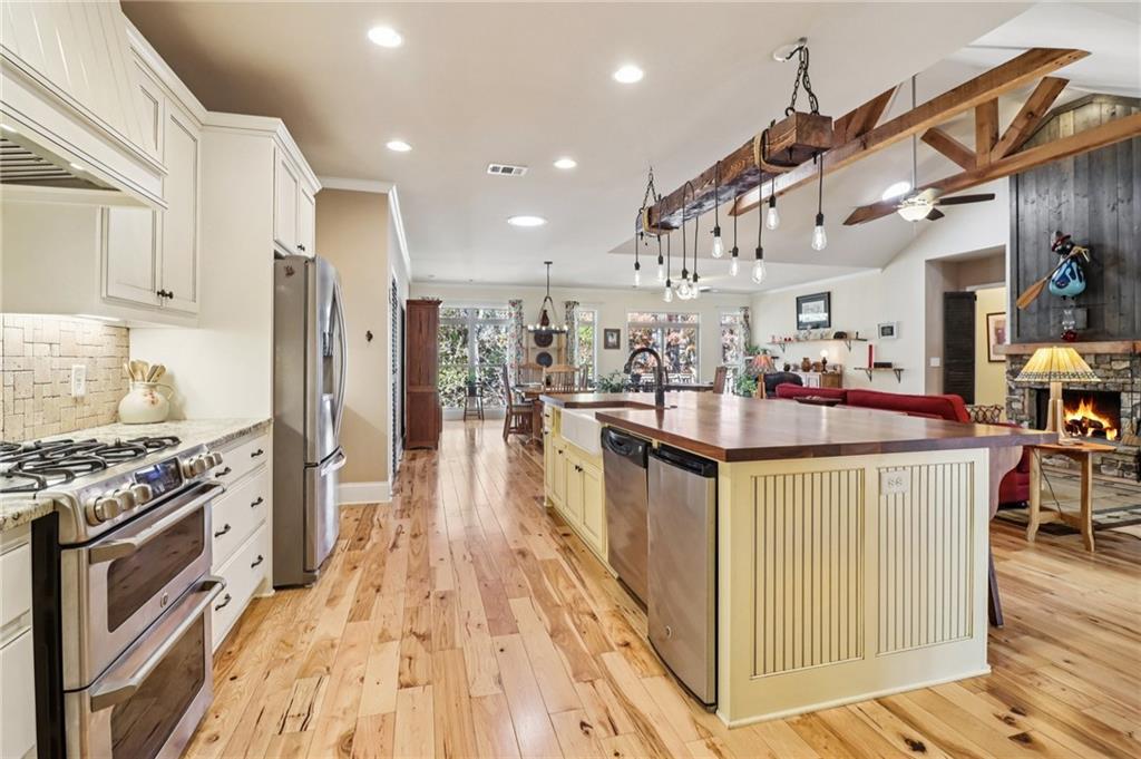 2007 Eagles Ridge Waleska, GA 30183 - Photo 11 of 45 a kitchen with stainless steel appliances kitchen island granite countertop a stove a sink dishwasher and a refrigerator with wooden floor