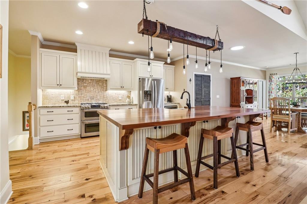 2007 Eagles Ridge Waleska, GA 30183 - Photo 9 of 45 a kitchen with stainless steel appliances kitchen island granite countertop a table chairs sink and cabinets