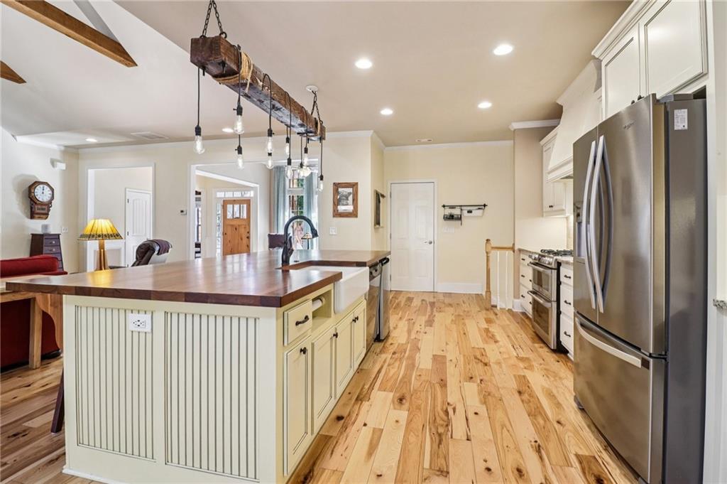 2007 Eagles Ridge Waleska, GA 30183 - Photo 10 of 45 a kitchen with stainless steel appliances a refrigerator a sink dishwasher a stove and a dining table with wooden floor